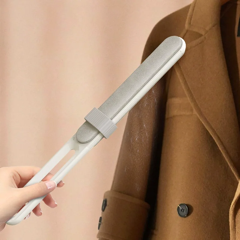 White felt pet hair removal brush with a sliding cleaning collar beside a coat, reference configuration